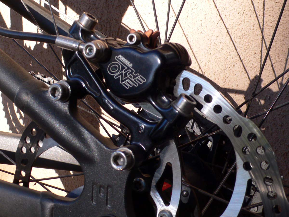 Тормозной диск на колесе велосипеда. Крепление для калипера заднего тормоза. Адаптер для калипера велосипеда SRAM. Задний дисковый тормоз на велосипед. Кронштейн для дискового тормоза на велосипед.